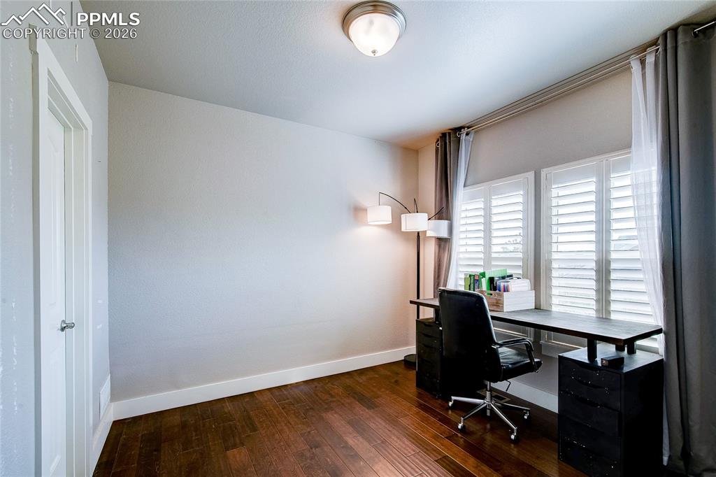 Image 8 of 44: Office featuring dark wood-type flooring and baseboards