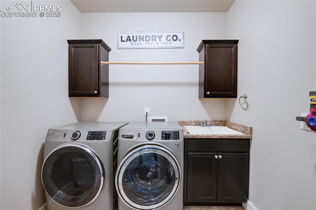 Image 9 of 44: Laundry area with independent washer and dryer and cabinet space