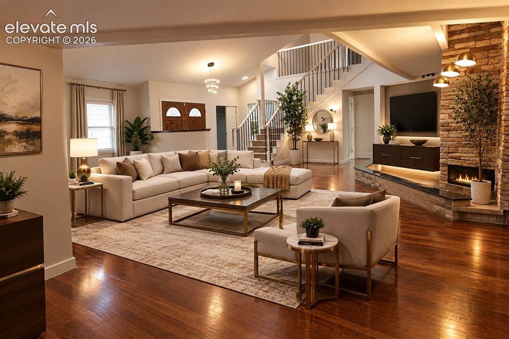 Image 6 of 50: Open-concept interior featuring wood-finish flooring, a floor-to-ceiling st