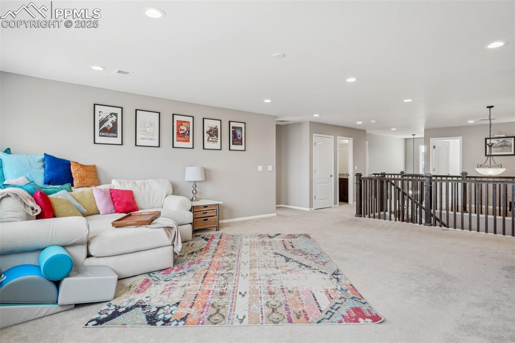 Image 24 of 50: Carpeted living area with recessed lighting and baseboards