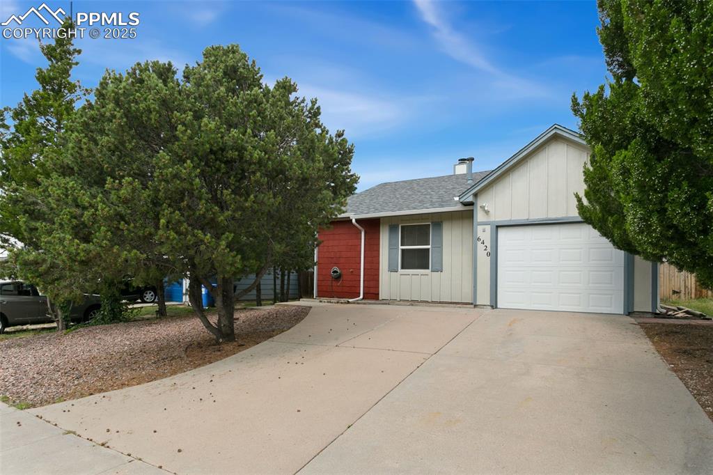 Caption: Single story home featuring driveway, board and batten siding, roof with shingles, a garage, and a c