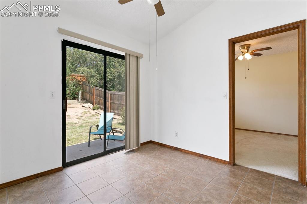 Image 10 of 24: Unfurnished room with a ceiling fan, light tile patterned floors, vaulted c