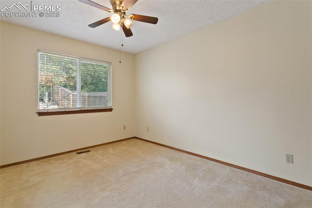Image 19 of 24: Empty room with a textured ceiling, carpet, and ceiling fan
