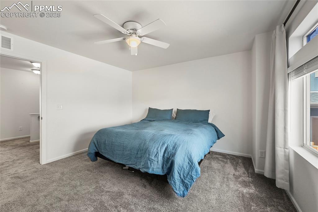 Image 16 of 28: Carpeted bedroom with ceiling fan and baseboards