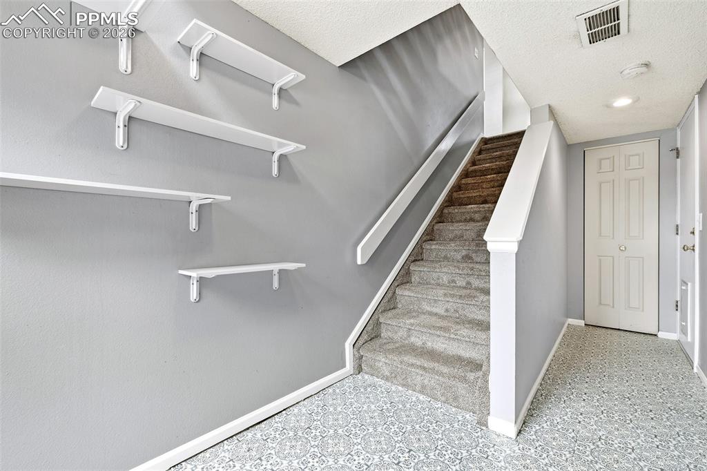 Image 22 of 30: The basement flex space and unfinished storage area with direct garage acce