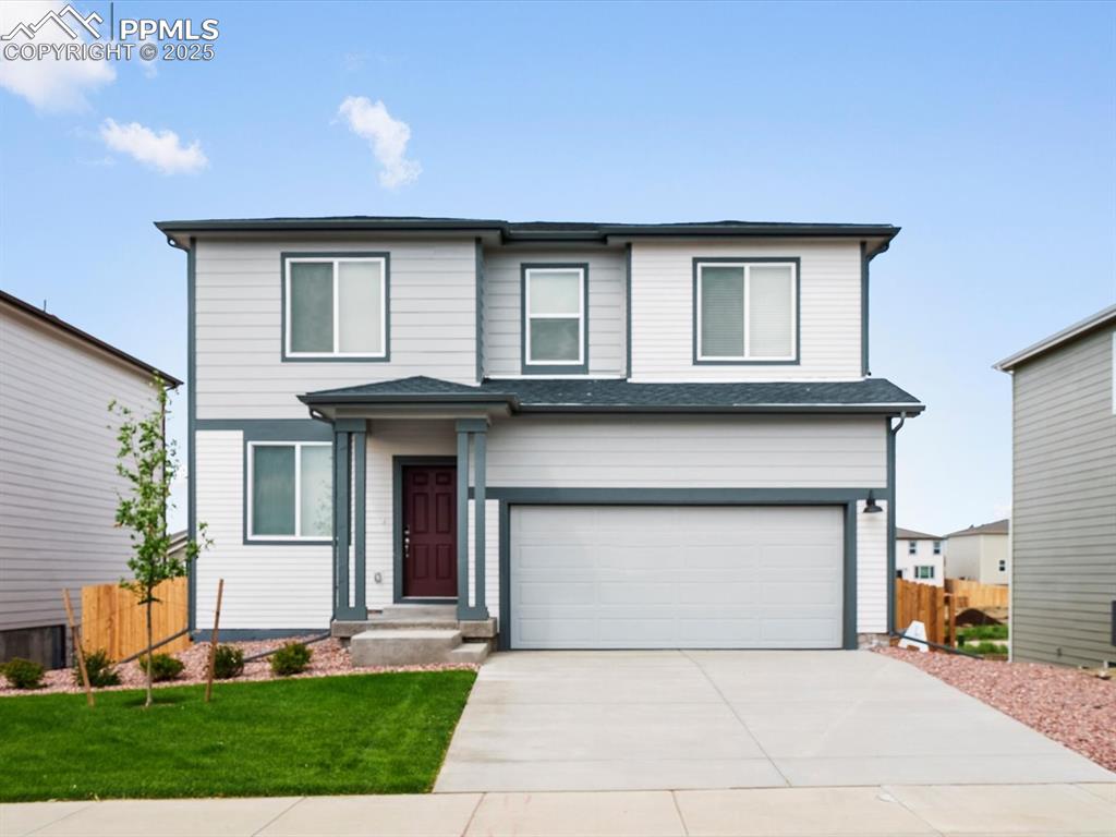 Caption: Traditional-style home with concrete driveway and a garage
