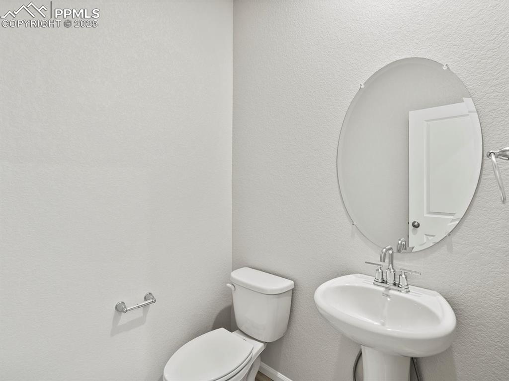 Image 11 of 28: Half bathroom with a textured wall and toilet