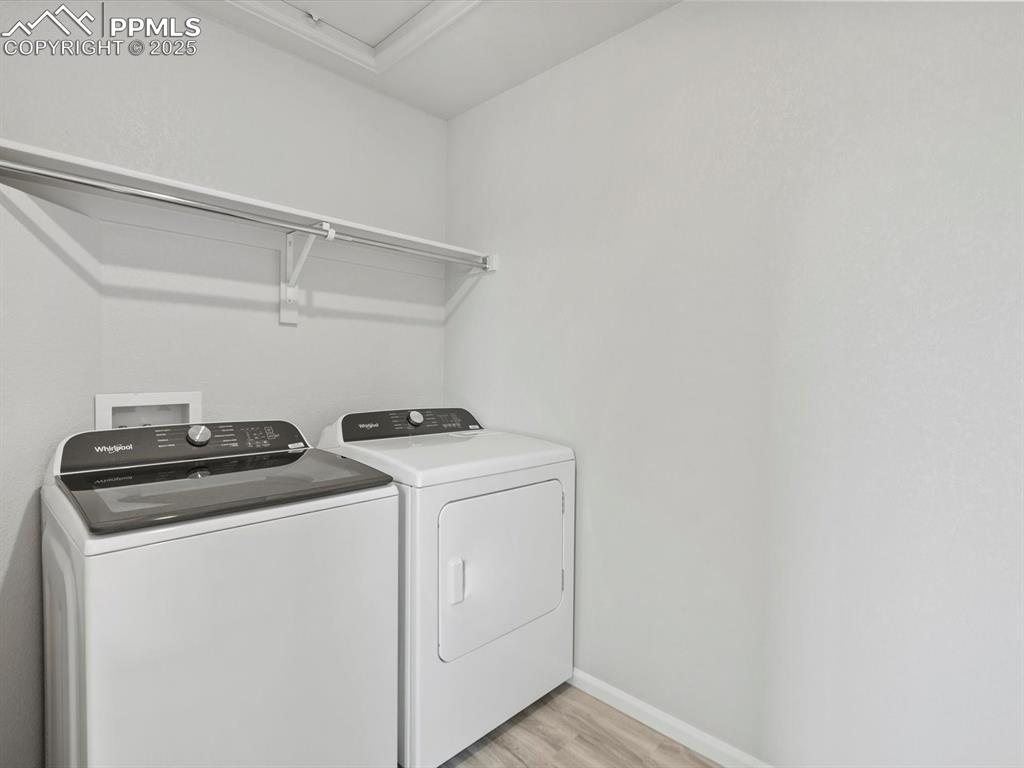 Image 12 of 28: Washroom featuring washing machine and dryer and light wood-style floors