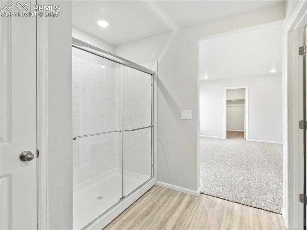 Image 23 of 28: Full bathroom with a stall shower, wood finished floors, and recessed light