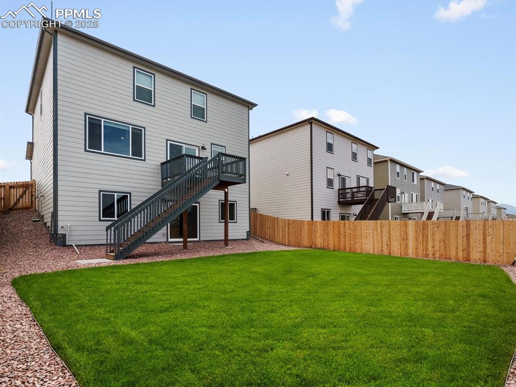 Image 25 of 28: Rear view of house featuring stairway, a fenced backyard, a deck, and a res