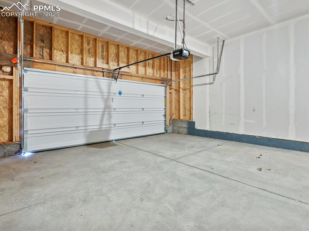 Image 26 of 28: Garage featuring a garage door opener