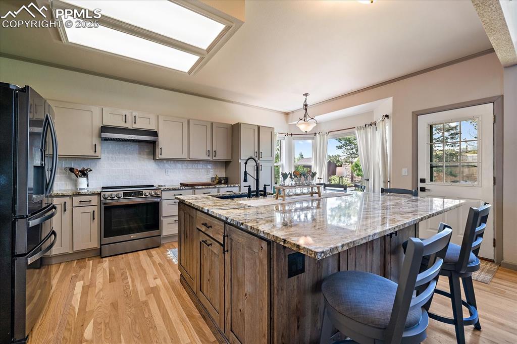 Image 10 of 47: Kitchen featuring stainless steel electric range oven, fridge with ice disp