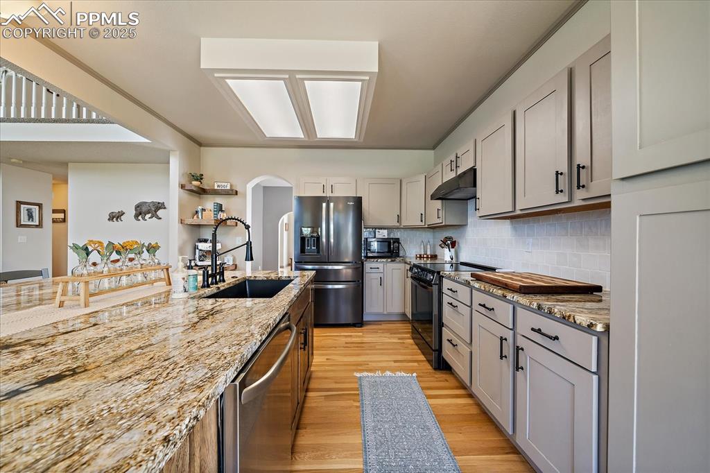 Image 12 of 47: Kitchen featuring electric range, refrigerator with ice dispenser, a sink, 