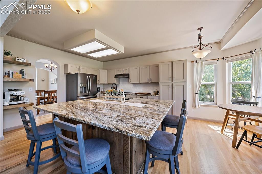 Image 14 of 47: Kitchen with stainless steel fridge, under cabinet range hood, a kitchen br