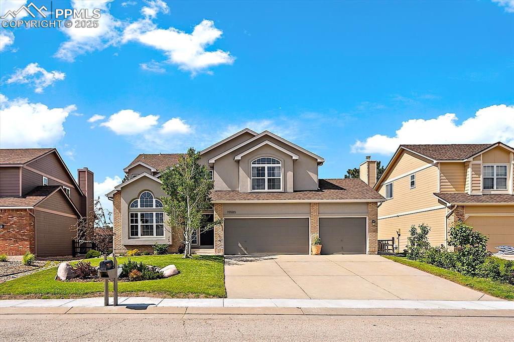 Image 2 of 47: Traditional-style home with stucco siding, brick siding, driveway, a garage