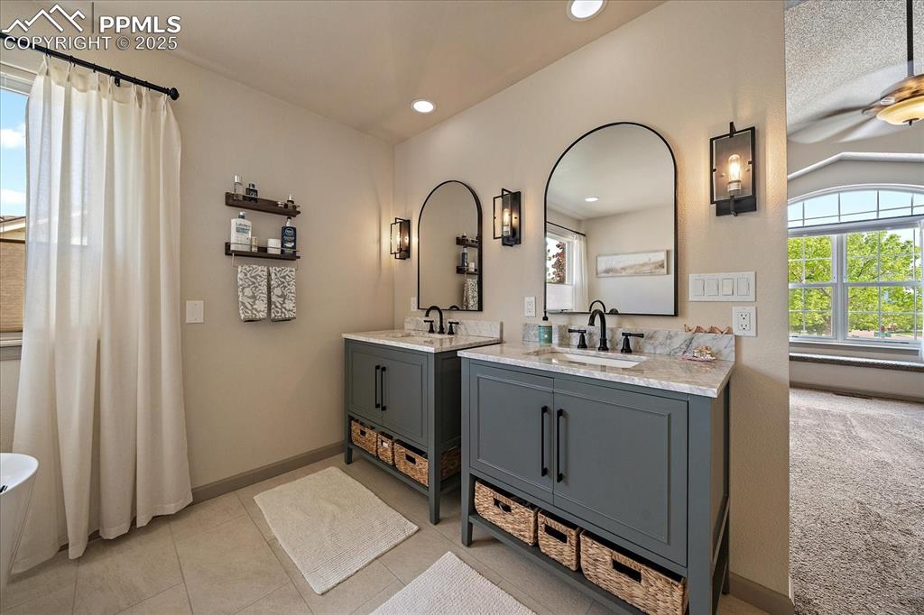 Image 26 of 47: Bathroom featuring two vanities, baseboards, recessed lighting, and tile pa