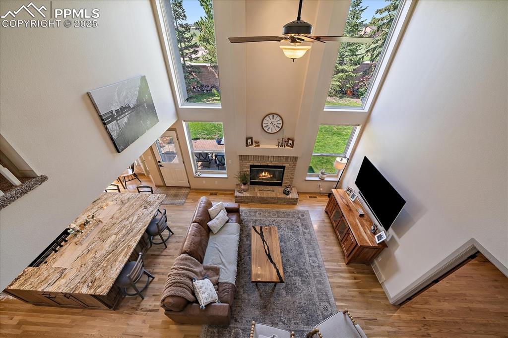 Image 30 of 47: Living area featuring a towering ceiling, wood finished floors, a fireplace