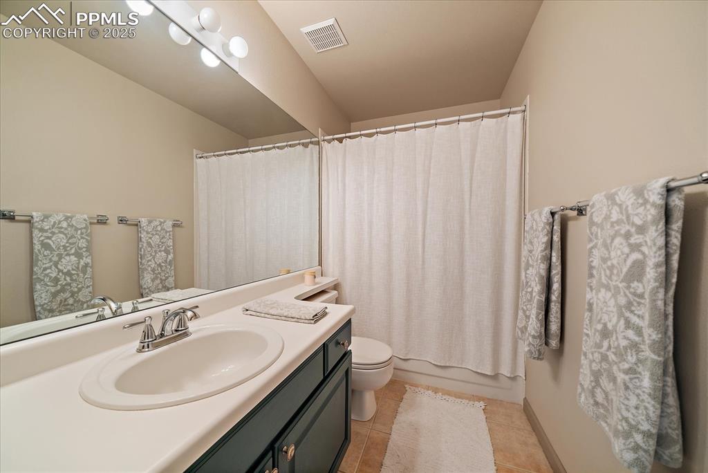 Image 32 of 47: Bathroom featuring vanity, toilet, and tile patterned flooring
