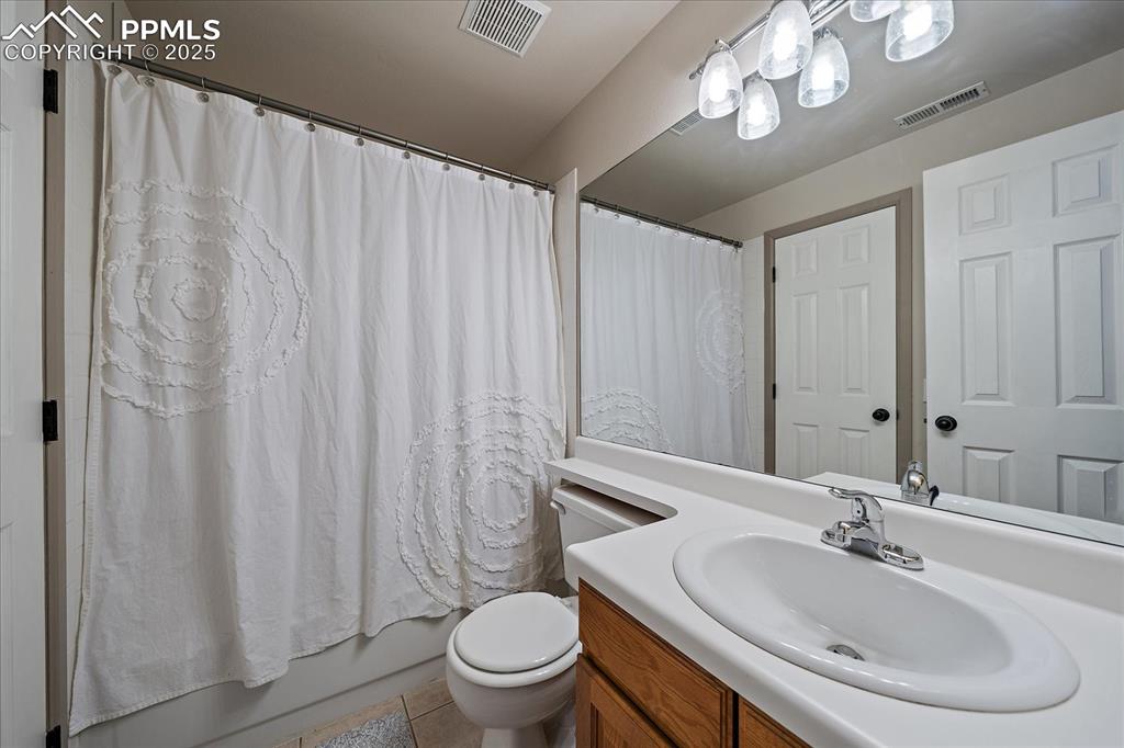 Image 40 of 47: Bathroom with vanity, toilet, shower / bath combination with curtain, and t
