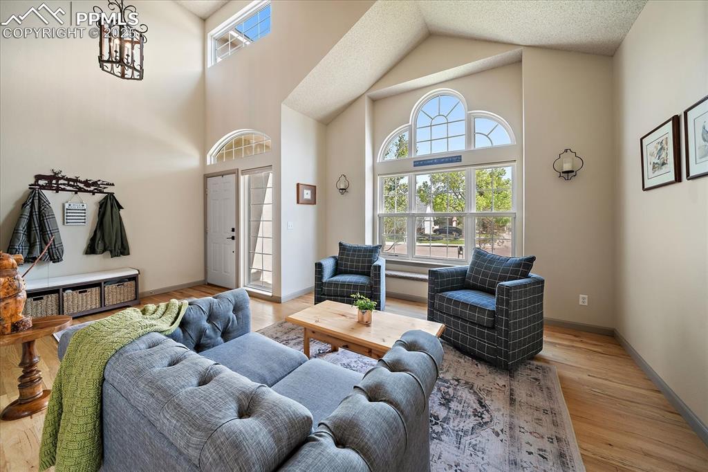 Image 6 of 47: Living room with healthy amount of natural light, a towering ceiling, light