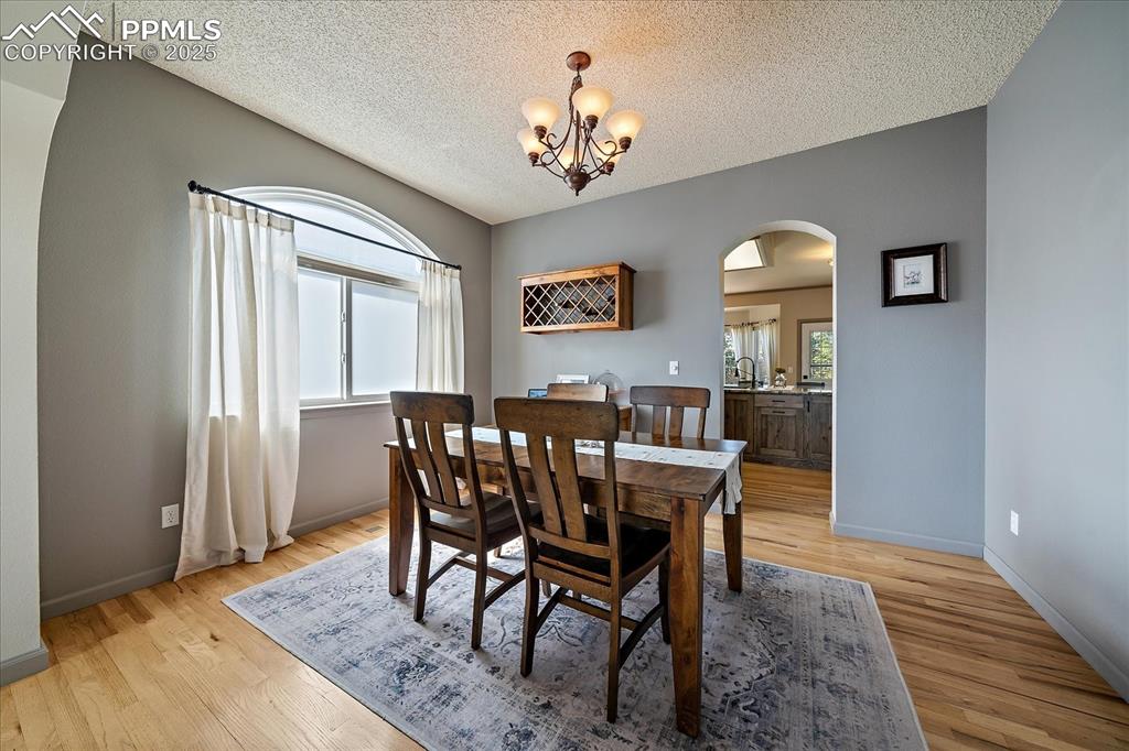 Image 9 of 47: Dining area featuring arched walkways, healthy amount of natural light, a c