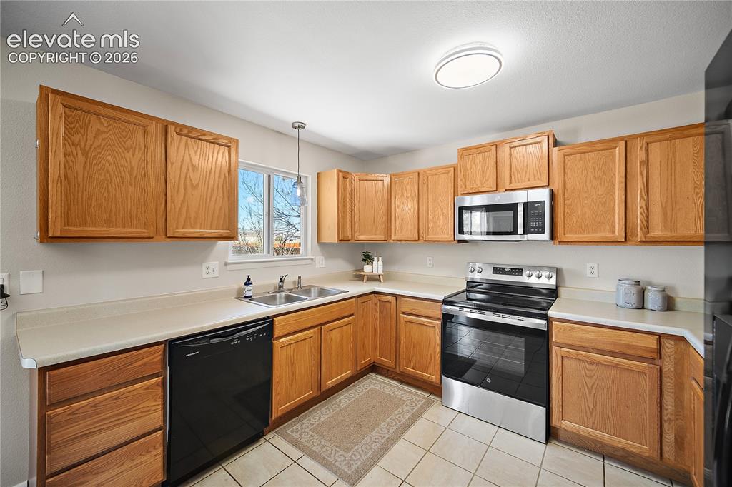 Image 11 of 29: Kitchen and dining area featuring wood-finish flooring, light wood cabinetr