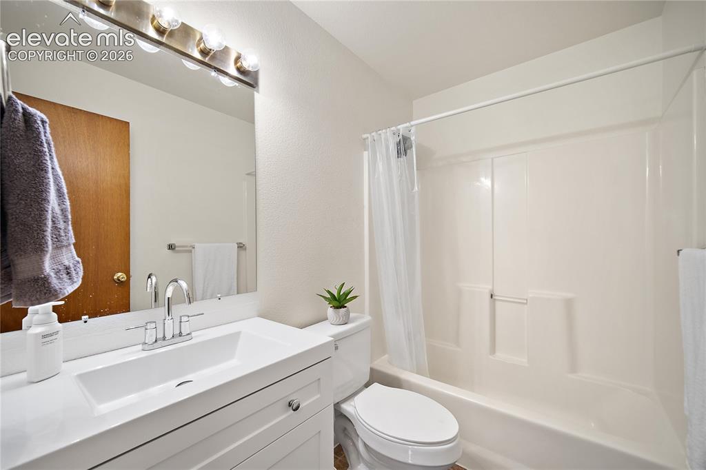 Image 13 of 29: Bright room featuring wood-finish flooring and a ceiling fan with integrate