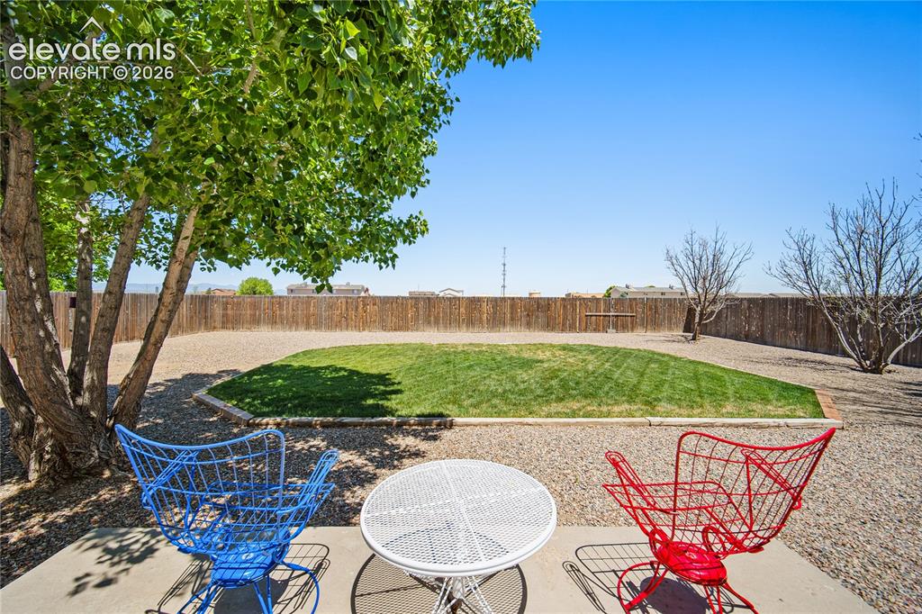 Image 21 of 29: Spacious backyard featuring a central grassy area, extensive gravel landsca