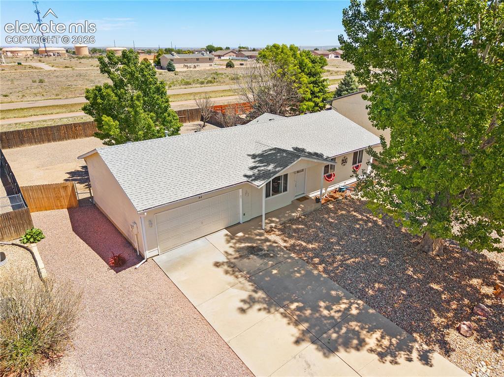 Image 27 of 29: Spacious backyard featuring a fenced perimeter, gravel landscaping, a centr
