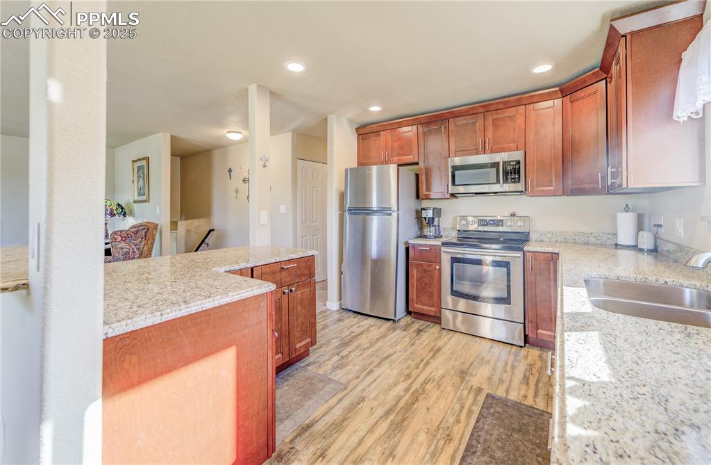 Image 11 of 25: Kitchen featuring light stone counters, stainless steel appliances, lots of