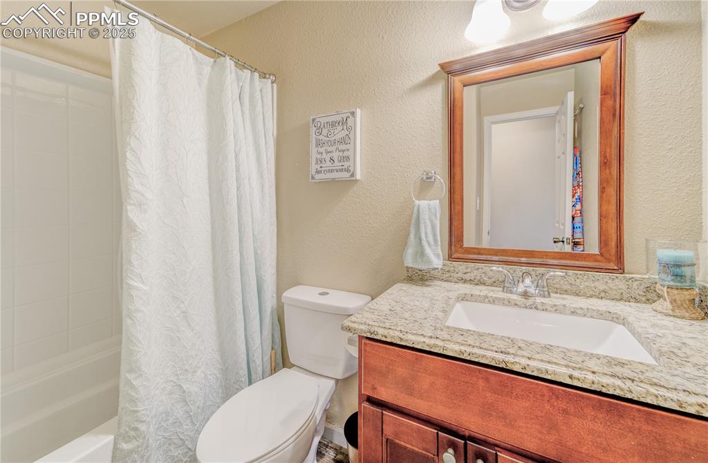 Image 12 of 25: Full bathroom with vanity, shower / tub combo, and toilet