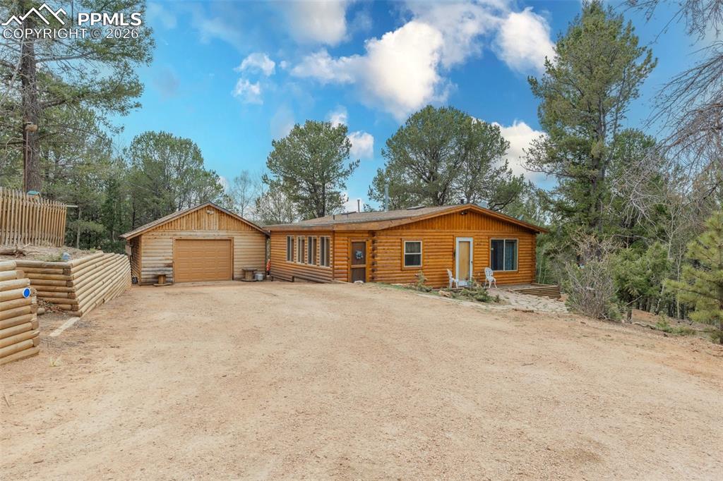 Image 1 of 41: Log cabin style residence featuring a detached garage, natural wood siding,