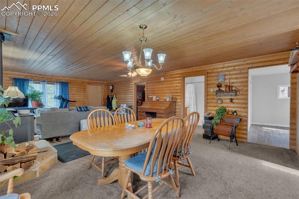 Image 11 of 41: Expansive room with wood-paneled walls and ceiling, featuring a central din