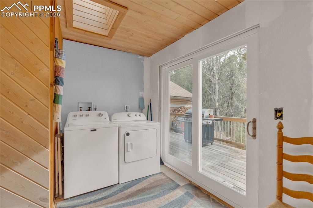 Image 16 of 41: Laundry area featuring a skylight and wood-paneled ceiling
