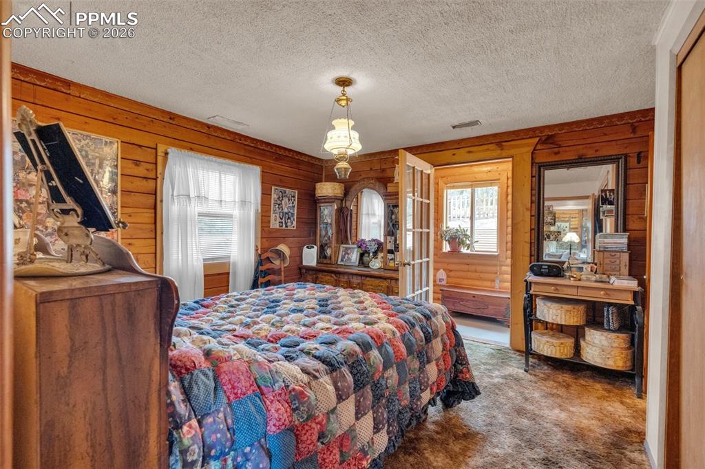 Image 17 of 41: Interior room featuring wood paneling throughout, a ceiling-mounted light f