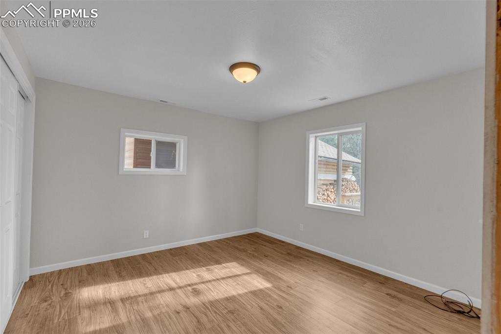 Image 22 of 41: Room featuring wood-finish flooring, light neutral wall paint, white trim,