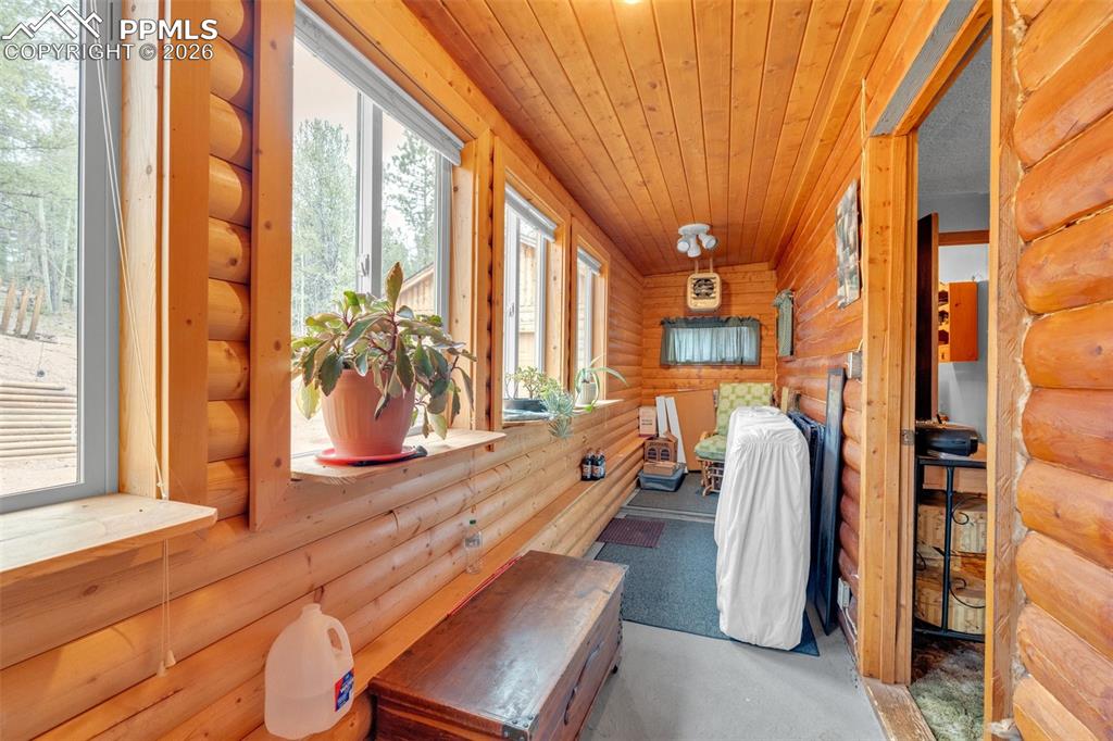 Image 24 of 41: Sunroom with extensive wood-finish wall and ceiling panels, multiple window