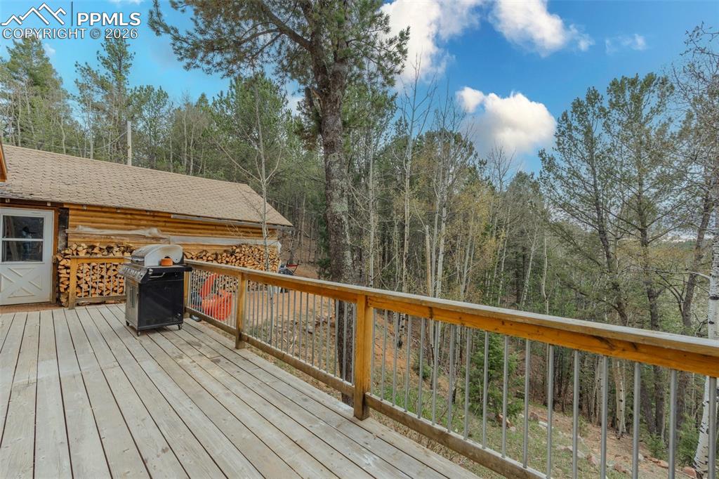 Image 27 of 41: Expansive wood deck with a natural wood railing and metal balusters