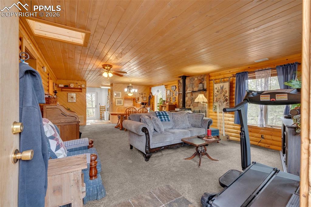 Image 4 of 41: Open-concept living space featuring wood paneling, wood-finish ceiling, and