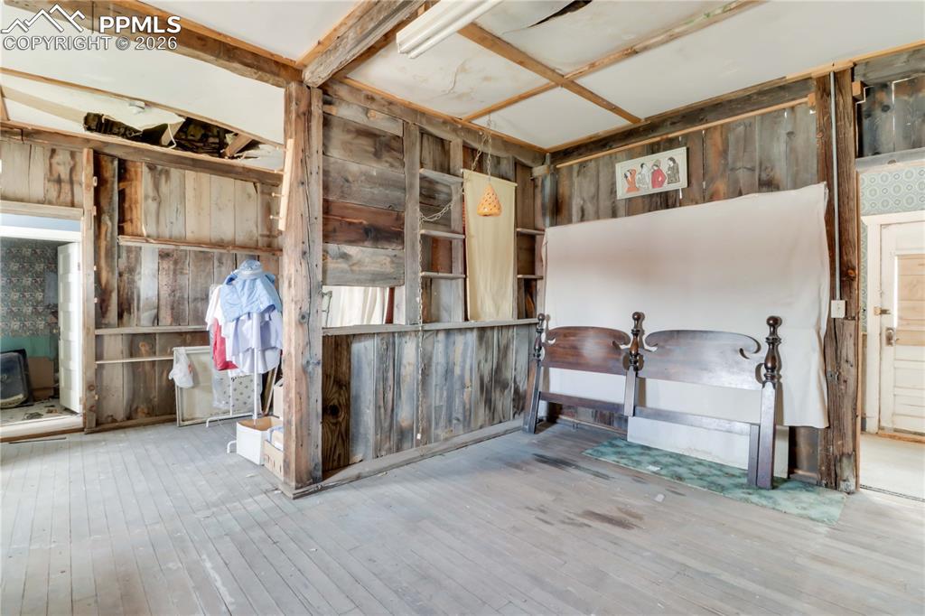 Image 15 of 36: Miscellaneous room with wood walls and wood-type flooring