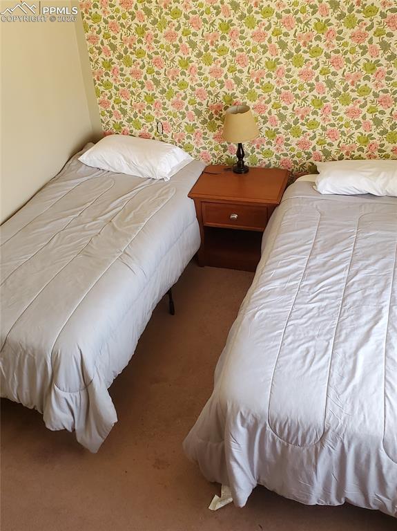 Image 25 of 36: Carpeted bedroom featuring wallpapered walls