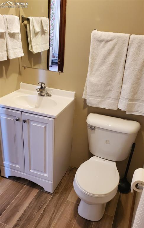 Image 27 of 36: Half bath with vanity and dark wood-style flooring