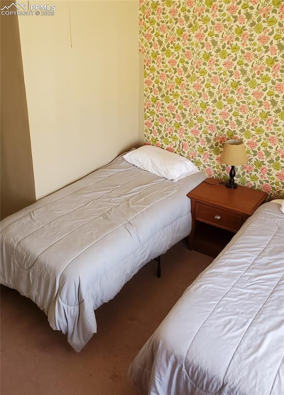 Image 28 of 36: Bedroom with wallpapered walls