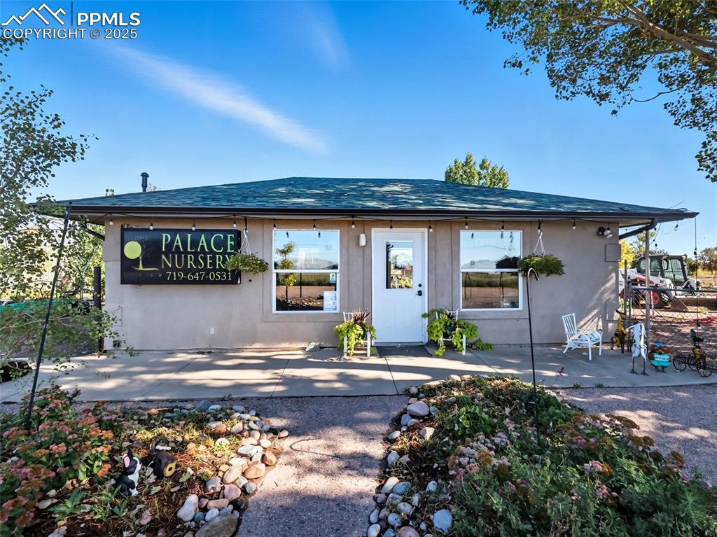 Caption: Bungalow-style home featuring roof with shingles and stucco siding