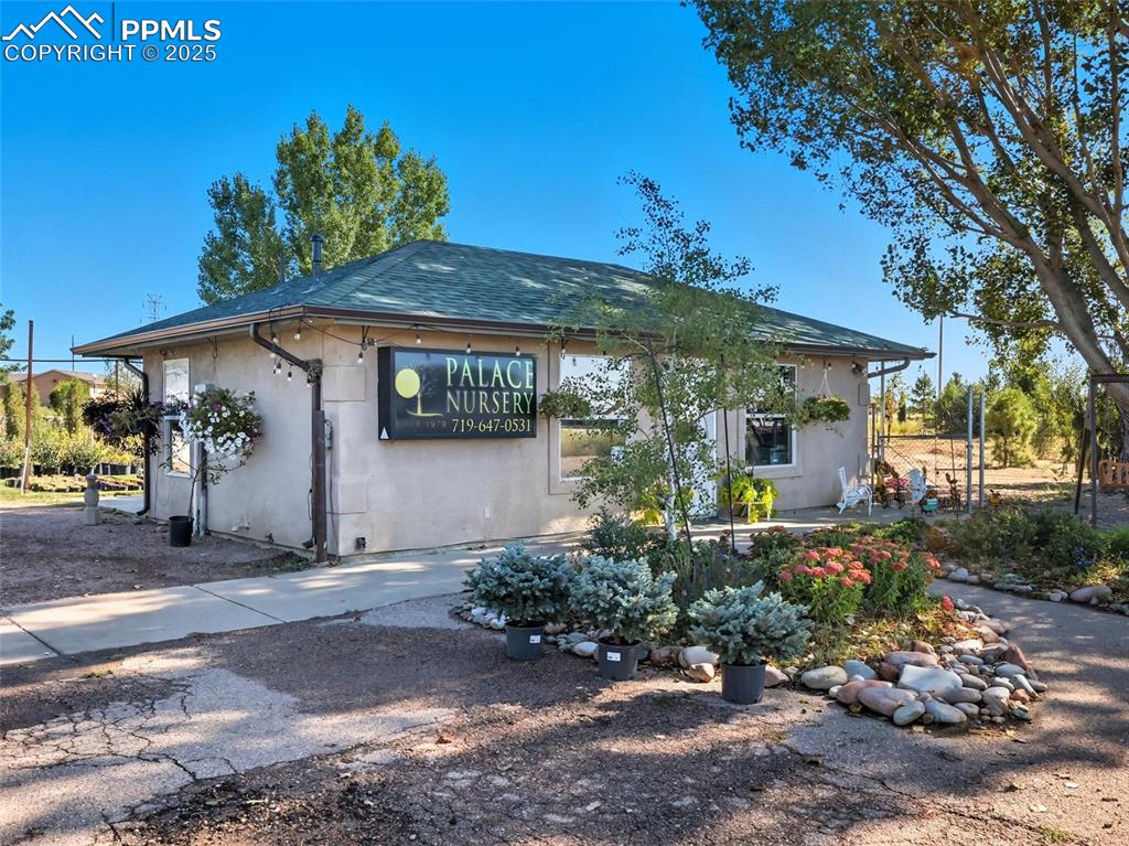 Image 2 of 12: View of front of home featuring stucco siding and roof with shingles
