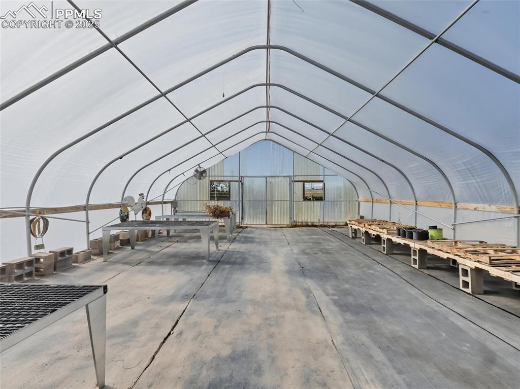 Image 9 of 12: Misc room with concrete floors and vaulted ceiling