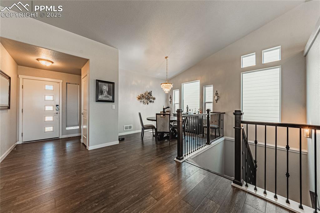 Image 11 of 49: Entrance foyer featuring dark hardwood / wood-style floors, vaulted ceiling