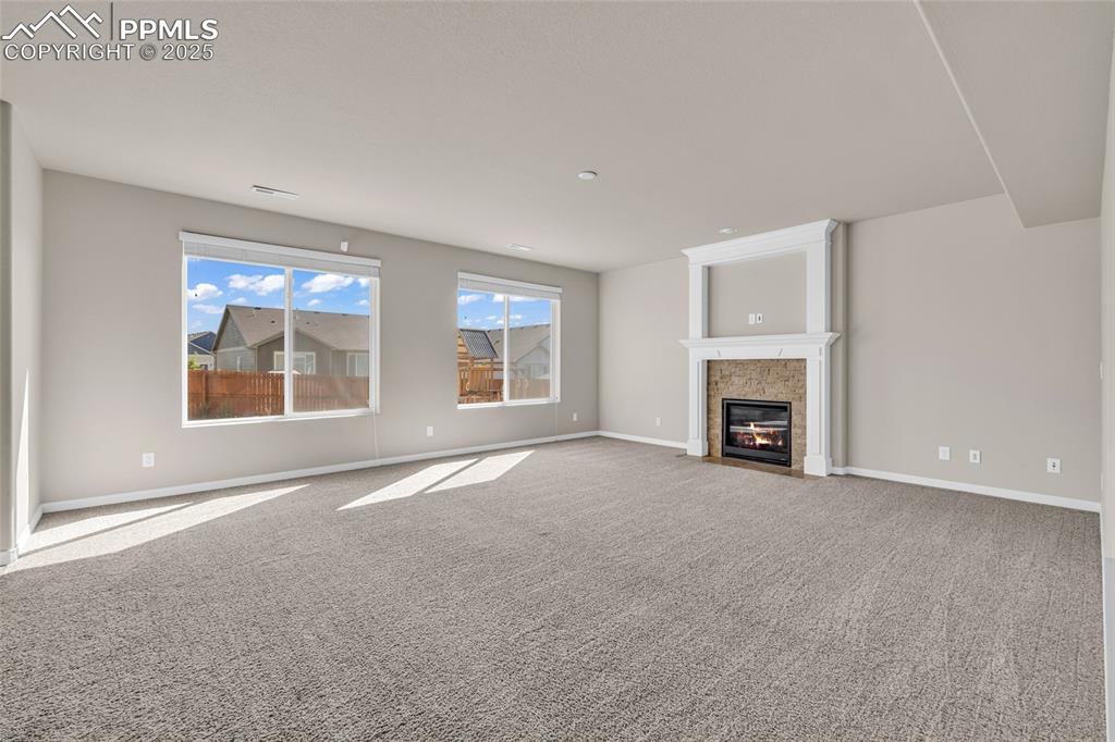 Image 12 of 44: Unfurnished living room with carpet and a fireplace