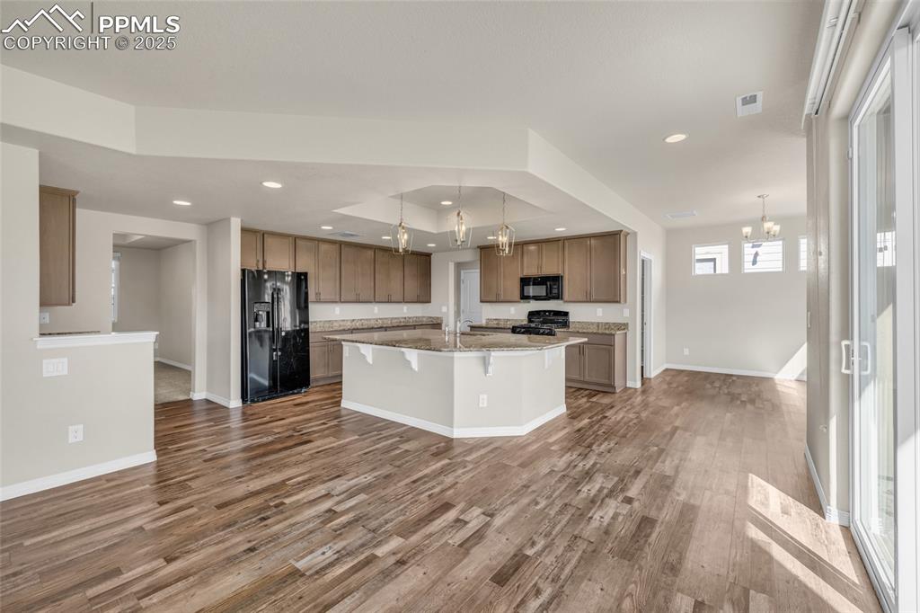 Image 13 of 44: Kitchen featuring a chandelier, hanging light fixtures, black appliances, a