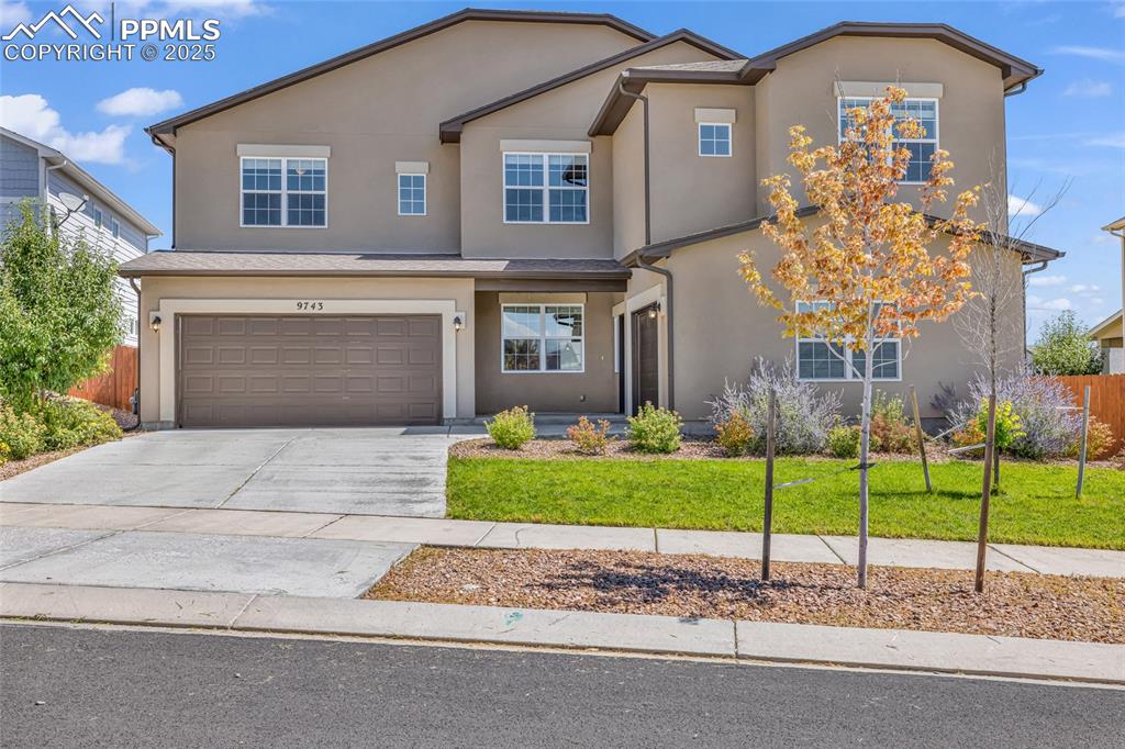 Image 2 of 44: Traditional-style home with driveway, an attached garage, and stucco siding